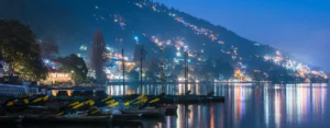 Naini Lake at night with city lights reflecting on water – best hill stations in Uttarakhand