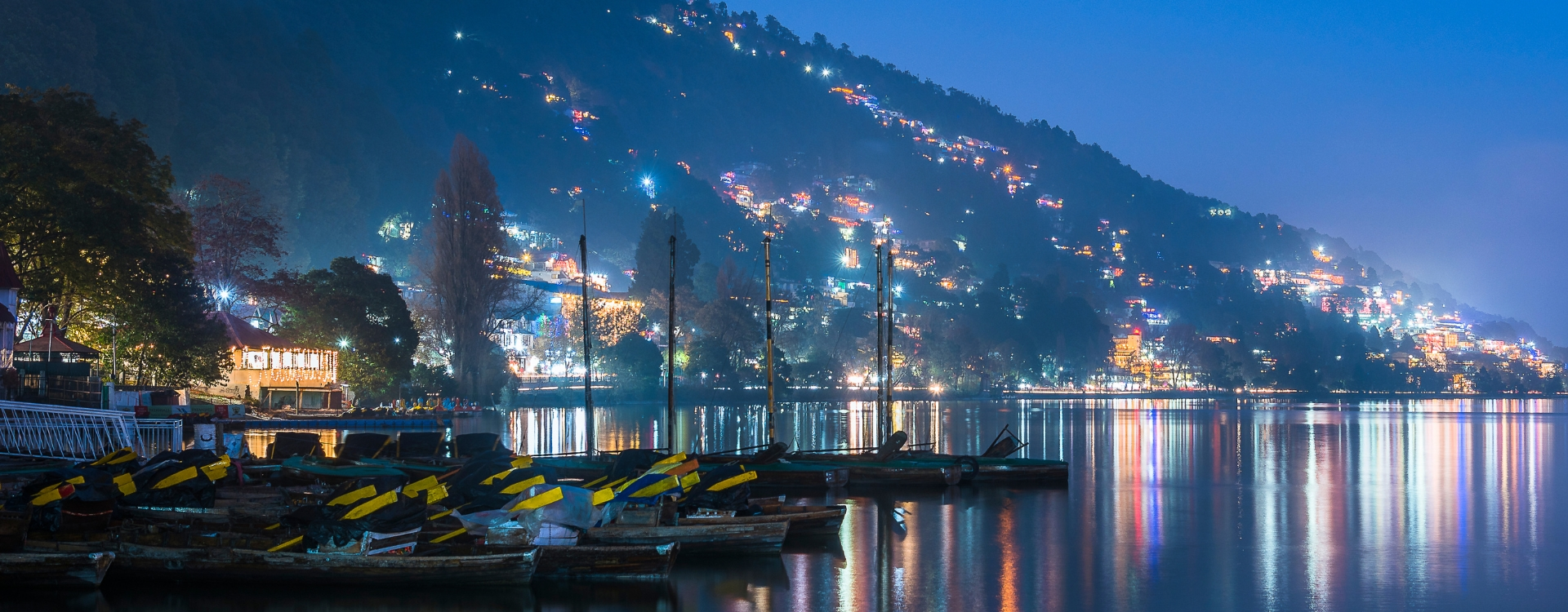 Naini Lake at night with city lights reflecting on water – best hill stations in Uttarakhand